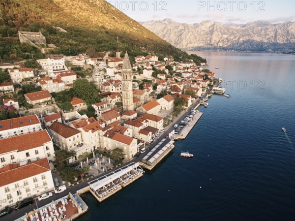 Perast promenade with outdoor restaurants on the piers by the sea. Montenegro. Drone.