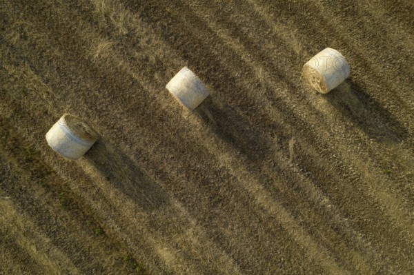 Aerial documentation of the classic straw balers in the fields in the summer season