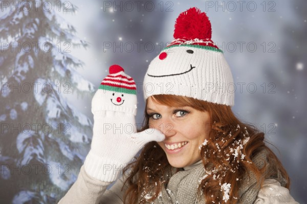 Portrait of woman in winter with snow and snowman hat