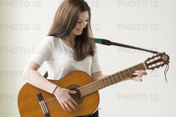 Cheerful girl playing guitar - copy space