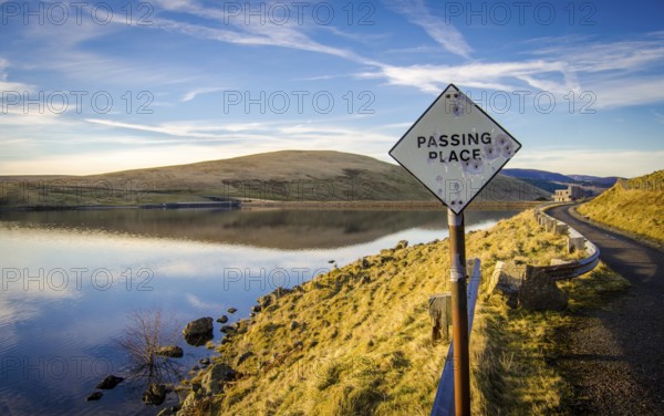 Passing Place Sign With Bullet Holes On Rural Road Beside A Lake In Scotland