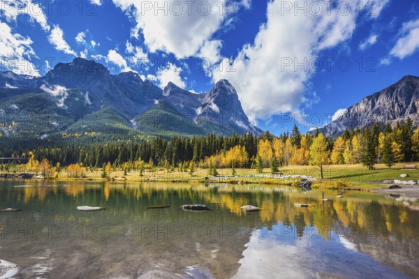 Shallow lakes surrounded by forests and mountains. Shining day in Canmore, Canadian Rockies. Concept of hiking