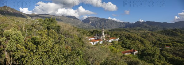 Aerial view panorama of Sanctuary Caraca with shadows, mountains, blue sky in background, Minas Gerais, Brazil, South America
