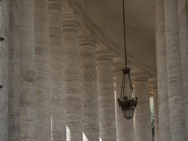 Atmospheric view of columns and lanterns in classical style in the interior of the Vatican, Rome, Italy, Europe