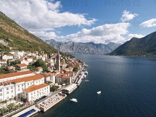 Swimming pool and private beach on the shore of the Bay of Kotor overlooking ancient houses. Perast, Montenegro. Drone.
