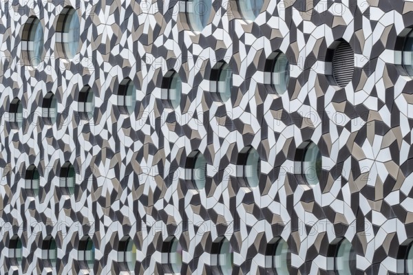 Facade with geometric patterns and circular windows creating a modern architectural design, London, UK