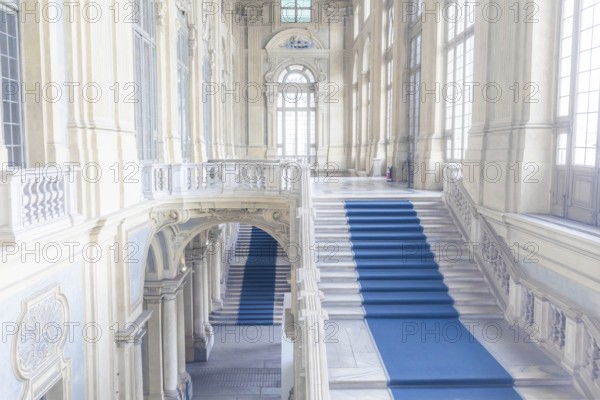 TURIN, ITALY, CIRCA JUNE 2021: The most beautiful Baroque staircase of Europe located in Madama Palace (Palazzo Madama) . Interior with luxury marbles, windows and corridors