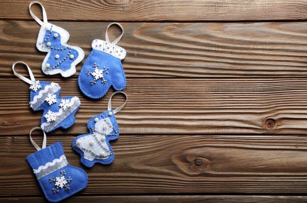 Handmade rustic felt Christmas tree decorations flat laying on wooden table