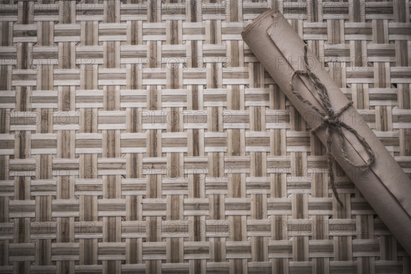 Vintage rolled corded paper on woven wooden matting