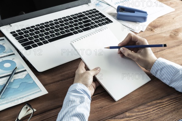 Close-up, female hands with notebook and pencil. Business woman working at the table in the office