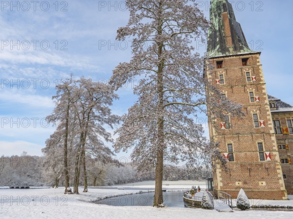 Castle on the water surrounded by snow-covered trees and wintry landscape under a blue sky, Raesfeld, münsterland, germany