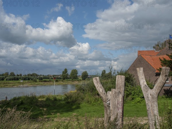 A peaceful riverside with expansive nature under a partly cloudy sky and a rustic ambience, zutphen, gelderland, netherlands