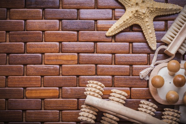Starfish wood massagers and bath brush on textured wooden table mat sauna concept