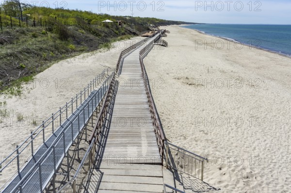 Wooden decking on the sea. Promenade on the sea beach. Deserted sea pier. Walking pier on the beach