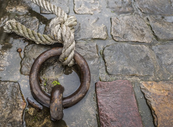 Close up image with a solid iron ring used to secure the anchoring of the ships on the docks, called mooring ring