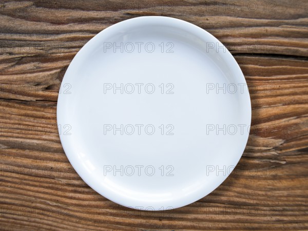 An Empty White Plate On A Rustic Wooden Table
