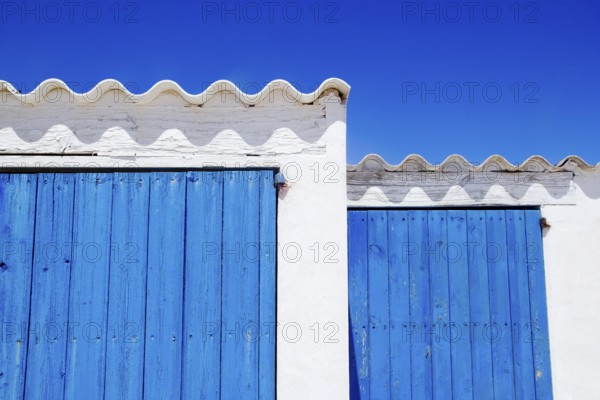 Vibrant blue doors contrast with white buildings in Balearic Islands
