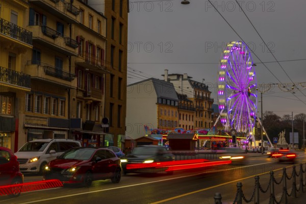 Traffic in Old Town with House and Building and Illuminated Ferris Wheel in a Cloudy Night in Neuchatel, Canton Neuchatel, Switzerland, Europe