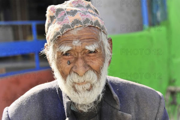 An aged man with a cap shows a striking face full of character, Pokhara Valley, Pokhara, Nepal, Asia