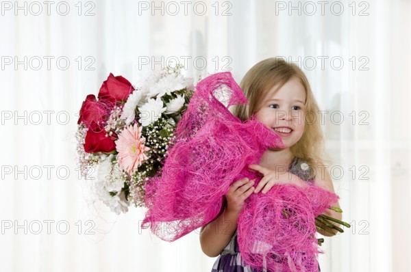 Beautiful little girl with a bouquet of flowers