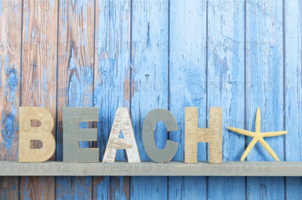 Blue wooden background with vintage beach text