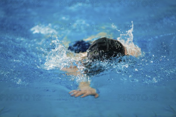 A swimmer swims in an indoor pool