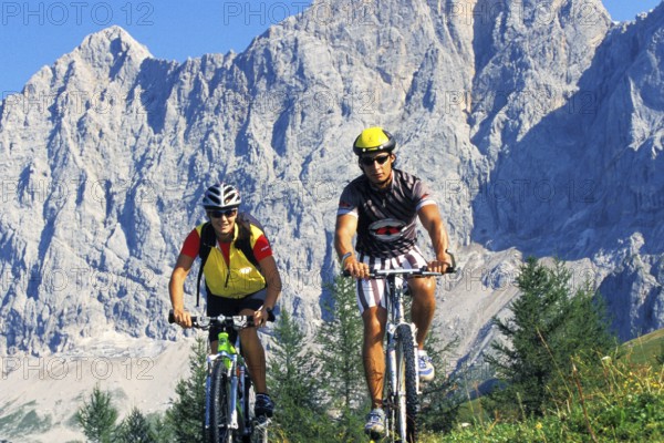 A man and a woman on a mountain bike in an alpine landscape, 30, 35, years
