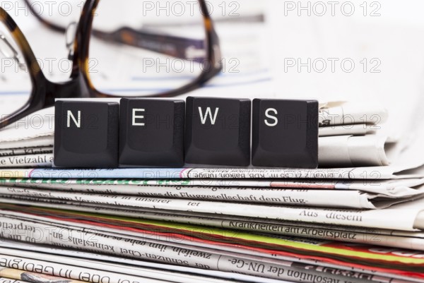 The image shows a stack of newspaper with set of letters