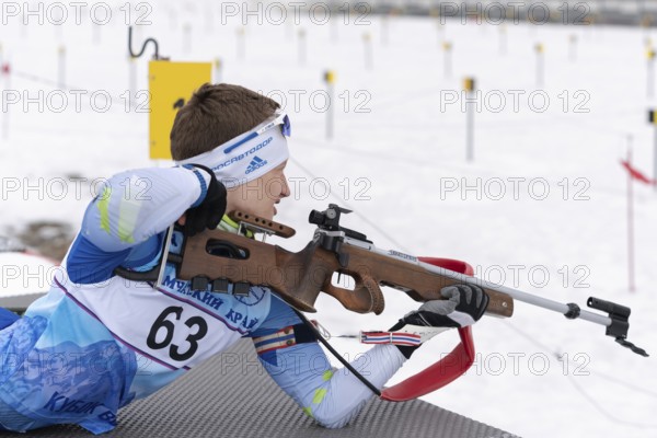 Sportsman biathlete Morilov Mikhail Khanty-Mansiysk rifle shooting in prone position. Biathlete in shooting range. Open regional youth biathlon competitions East Cup. Kamchatka, Russia, Apr 12, 2019, Europe