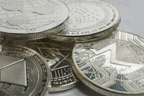 Macro photo of Ripple cryptocurrency physical coin surrounded with variety of other crypto altcoins