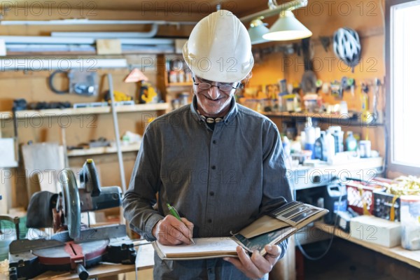 Selective focus on Inspector in the garage interior during an inspection. middle aged caucasian man wearing helmet writes notes on a notebook
