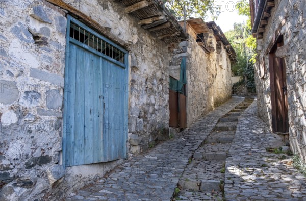 Stoned footpath crossing a traditional village. Stoned houses with wooden doors. Vintage architecture. Palaichori village, Cyprus, Europe