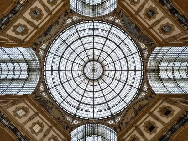 Round stained-glass windows and arches on the ceiling of the Vittorio Emmanuel Gallery. Milan, Italy.
