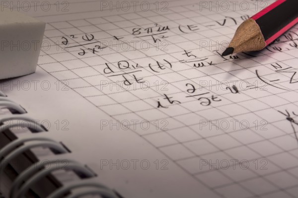 Pencil on notebook, full of mathematical formulas