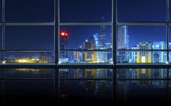 Modern empty and clean office interior with glass windows, Kuala Lumpur city skyline background, night scene