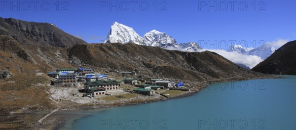 Lodges in Gokyo, turquoise lake and snow covered mountain Cholatse, Nepal, Asia