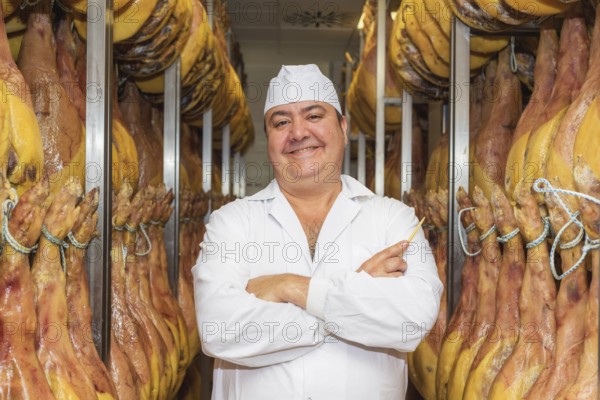 Man controlling the curing of spanish jamon. Food industry concept
