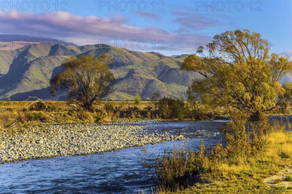 Valley at the foot of the Clay Cliffs and a slow river. Fabulous country of New Zealand. Travel to the South Island. Warm evening. The concept of active, exotic and phototourism