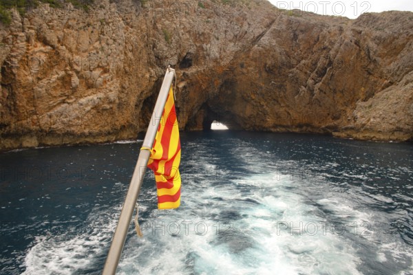 Rocks and flag at the coast Costa Brava Spain