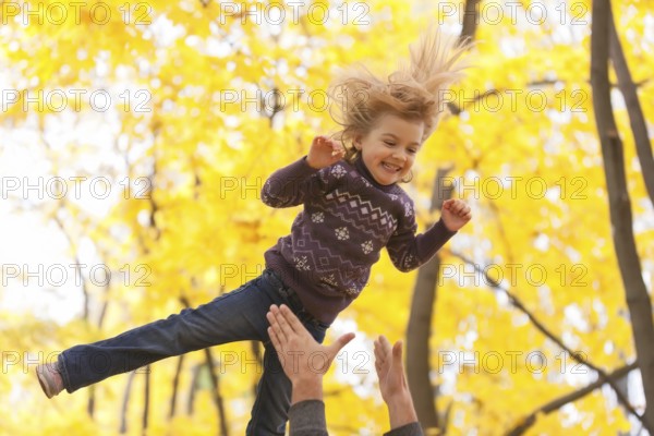 Cute little girl jumping in the autumn forest