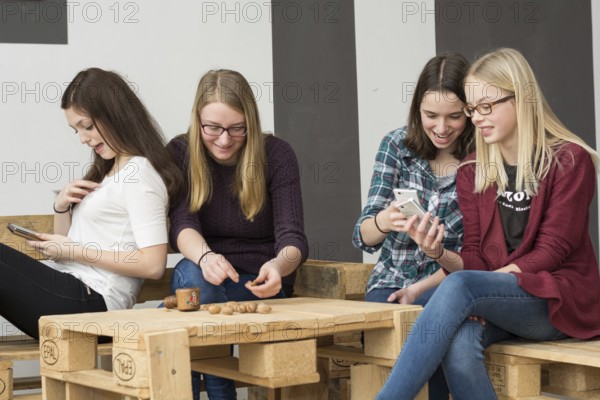 Funny group of teenagers with their smartphones