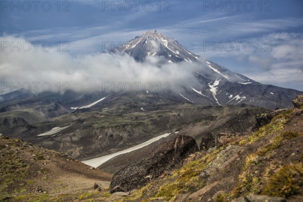 Mountains and volcanoes. Beautiful landscape of Kamchatka Peninsula: summer panoramic view of Mountain Range Vachkazhets, mountain lake and clouds in blue sky on sunny day. Eurasia, Russian Far East, Kamchatka Region