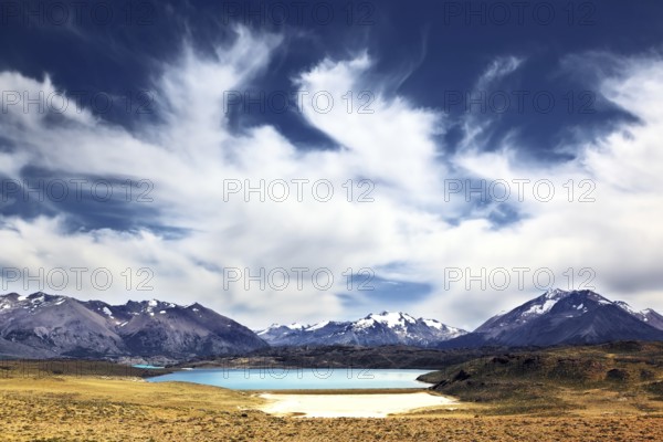 The huge deserted National Park Perito Moreno in Patagonia, Argentina. Strong wind turns the clouds in a valley surrounded by snow-capped mountains