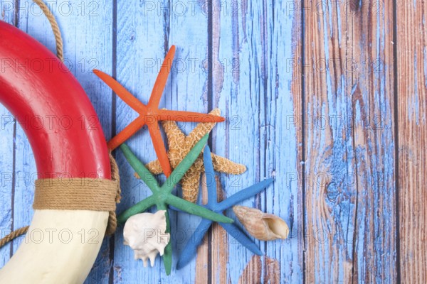 Beach poster on wooden background with starfishes and life buoy