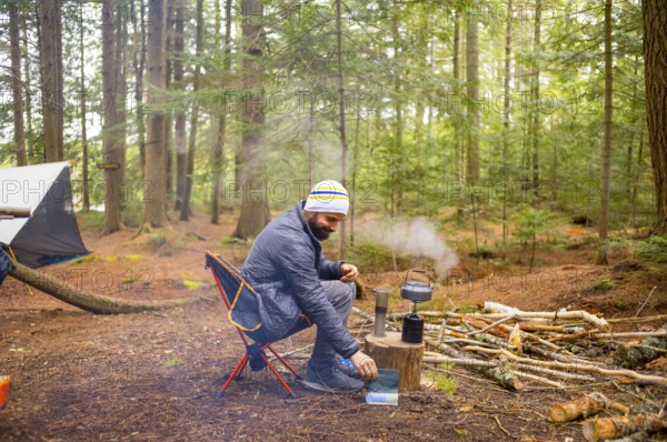 Man in a Camping Sight of Natural Reserve in Little Tupper Lake Park, New York State - US