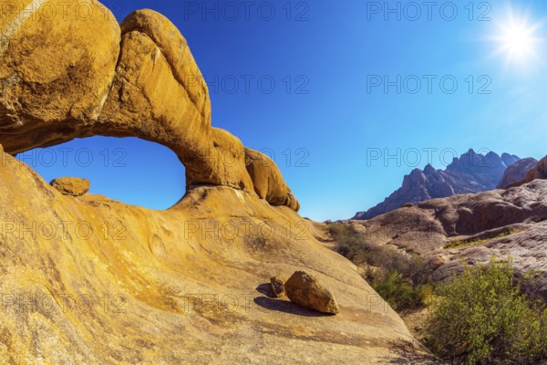 Picturesque stone arches are painted by iron oxides in red-orange color. Nature reserve Spitzkoppe in Namibia. Sunrise