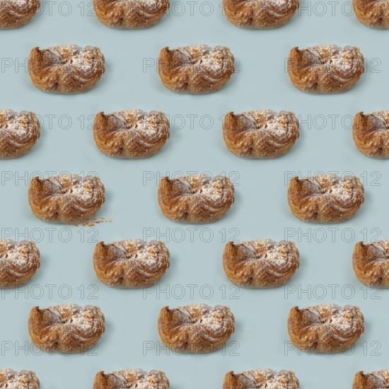 Puff pastry buns of fancy shape, with crumbs, on a blue background, pattern