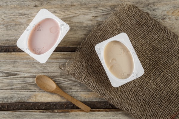 Natural organic yogurt with natural juice on a wooden background with a natural bamboo spoon
