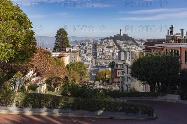 A picture of the Coit Tower atop the Telegraph Hill as seen from the Lombard Street, in the fall