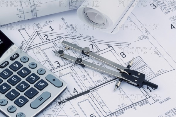 An architect's construction plan with a calculator. Symbolic photo for financing and planning a new house. Austria